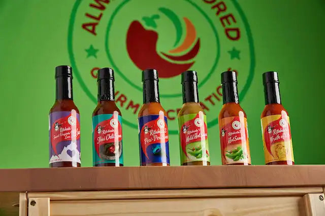 Six bottles of hot sauce lined up in a row.