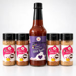 A tall glass bottle of sweet virginia love bbq sauce with a purple label and black cap surrounded by four honey butt bbq rub jars