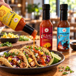 Yellow-labeled fafo heat pack hot sauce bottle with black cap pouring vibrant orange-red sauce over tacos