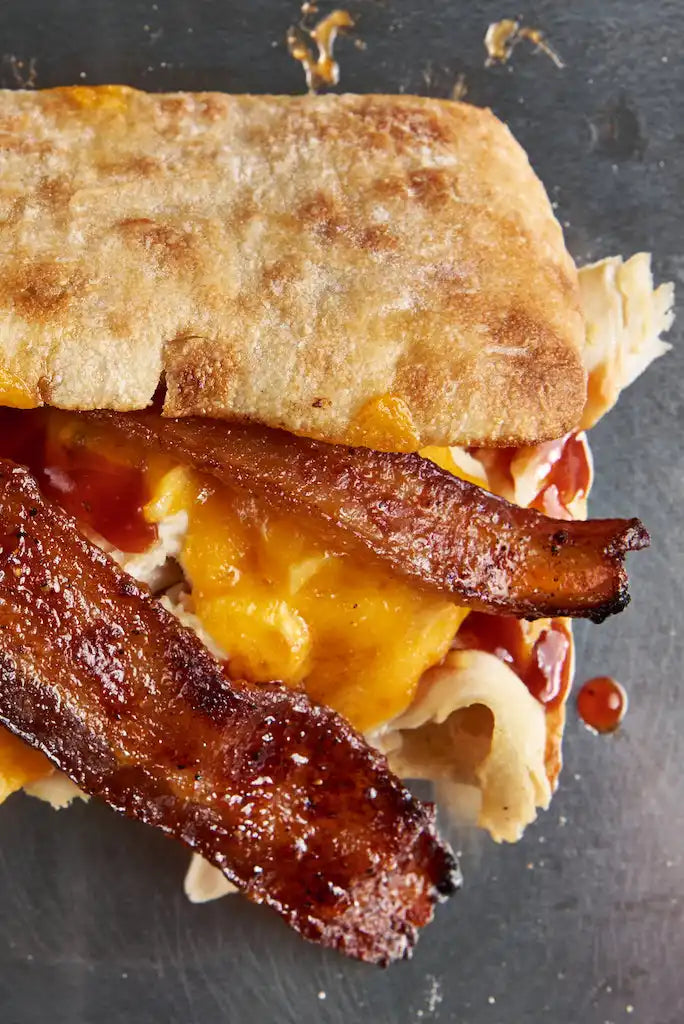 Grilled sandwich filled with melted cheese and crispy bacon strips.