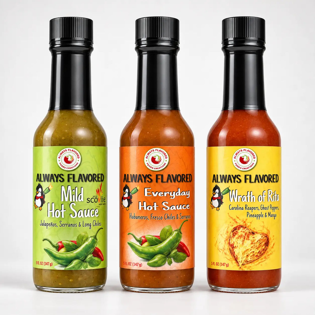 Three glass bottles of always flavored hot sauce with black caps and colorful labels in the rita heat flight collection